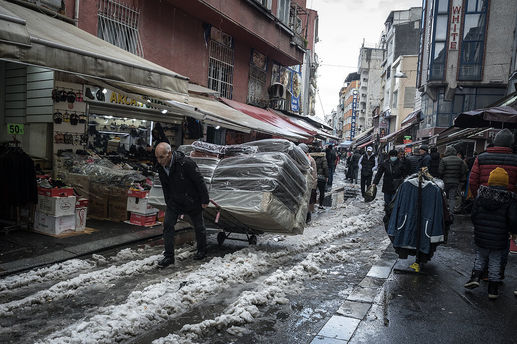 伊斯坦布尔的一名土耳其男子拖着援助组织购买的床垫，帮助在该市重新安置的俄罗斯人。