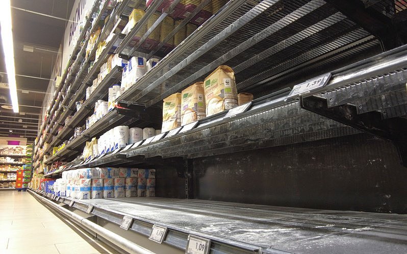 由于时局不稳，欧洲消费者想储备日常食品。 超市食用油、面粉、卫生用品等都成了抢手货。 图为德国波恩一家超市面粉货架16 日几乎空空如也。 路透