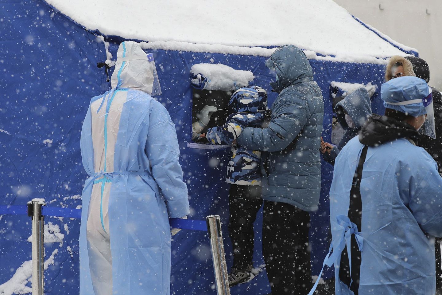 2022年3月15日，吉林省长春市下雪时，居民排队进行核酸测试。（AP）