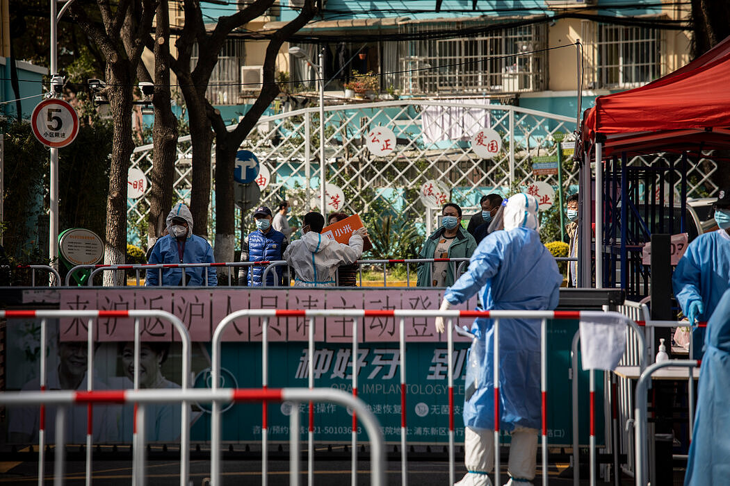 在上海一个被封锁的社区，检疫检查站的工作人员正在接收居民买的东西。