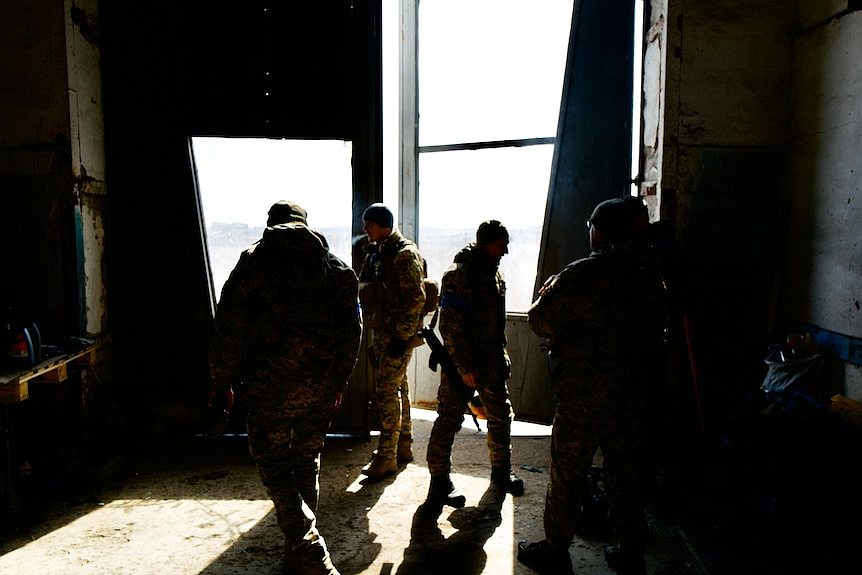Ukrainian soldiers in the 28th Brigade prepare inside a warehouse