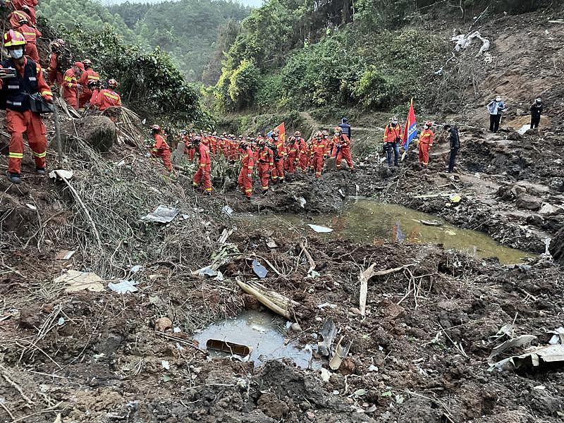 中国东方航空公司一架波音737客机21日在广西断崖式坠机，搜救人员在现场找寻黑盒子下落。(新华社)