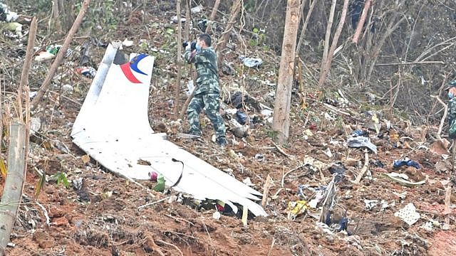 广西梧州藤县中国东航MU5735航班坠落事故坠落现场武警在一片机翼残骸旁边作业（新华社图片22/3/2022）