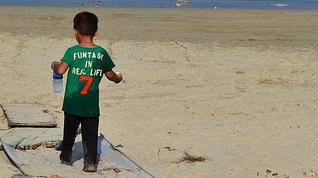 A local child on his way to play on the beach in Sai Wan...