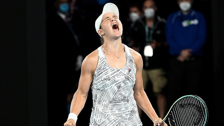 Ash Barty screams with both fists clenched, one around a tennis racket, after winning the Australian Open final.