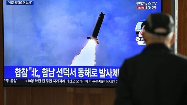 A man watches a television news broadcast showing a file image of a North Korean missile test, at a railway station in Seoul on March 9, 2020. - Nuclear-armed North Korea on March 9 fired what Japan said appeared to be ballistic missiles, a week after a similar weapons test by Pyongyang. (