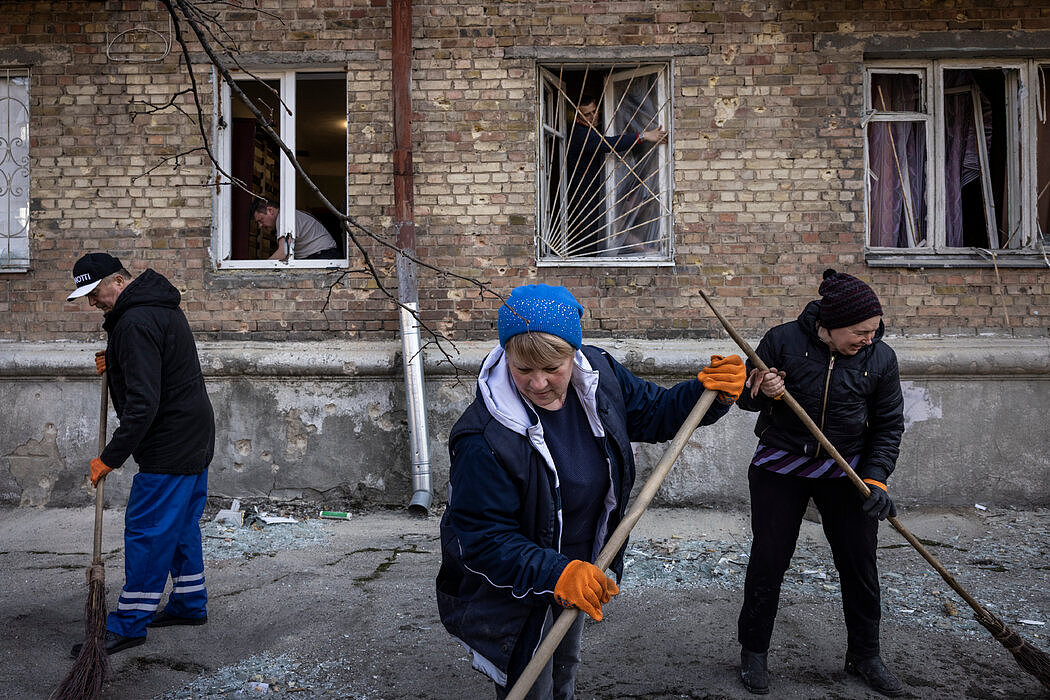 周三，基辅居民和志愿者在清理空袭留下的瓦砾，修理窗户。