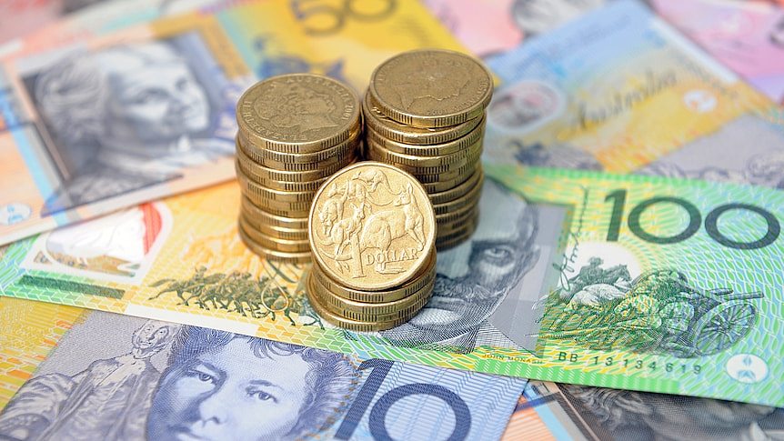 Picture of Australian one dollar coins stacked on top of note currency