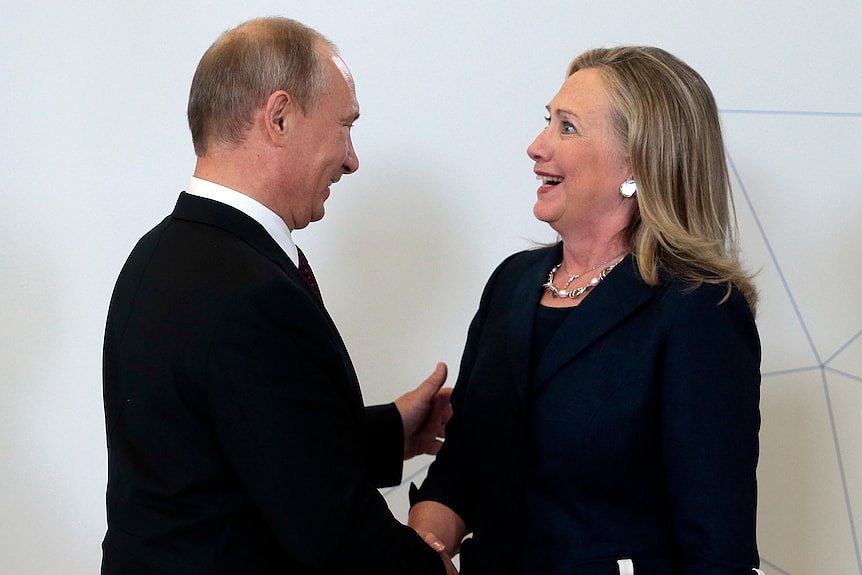 Hillary Clinton looking startled as she shakes hands with Vladimir Putin 