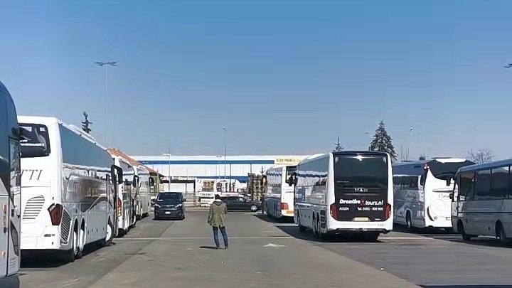 coaches and vans parked before the refugee center