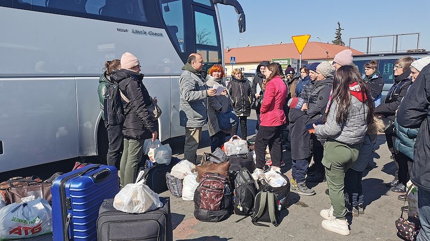 refugees around a coach outside Tesco 