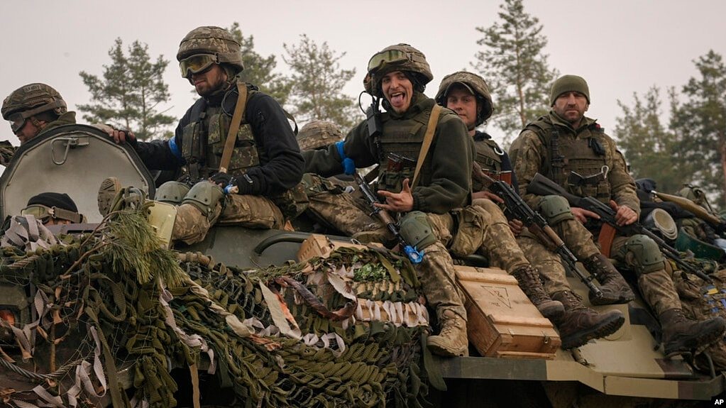 在基辅城外,乌克兰军人坐着装甲车通过被乌军攻破的俄军阵地。(2022年3月31日)