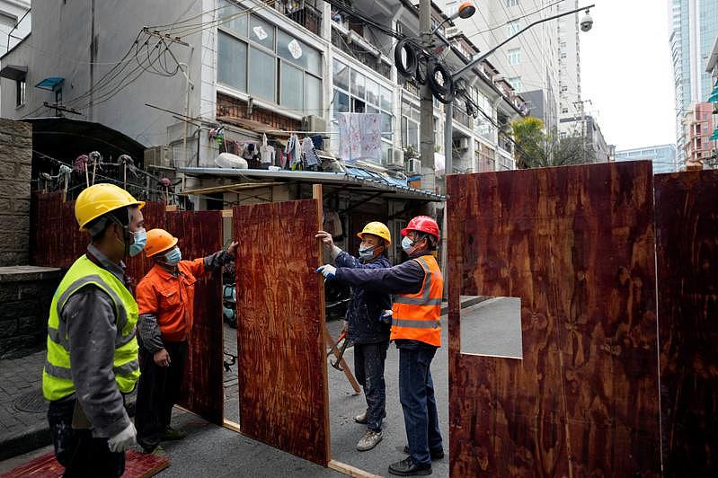 上海市防疫实施「管控区」，实行「人不出区，严禁聚集」。图为工作人员用木板将社区封闭，禁止进出。（路透）