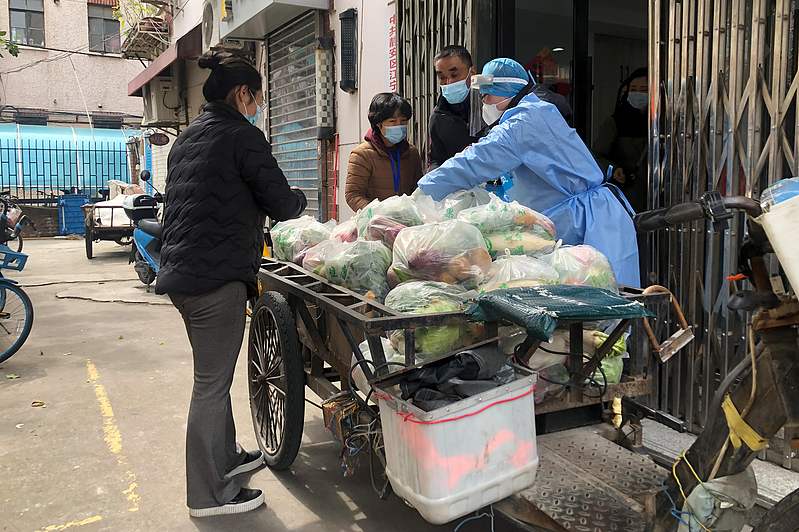 上海浦西地区1日实施封控，所有民众都被要求「足不出户」。图为静安区一处街道居委会为民众配送蔬菜上门。美联社