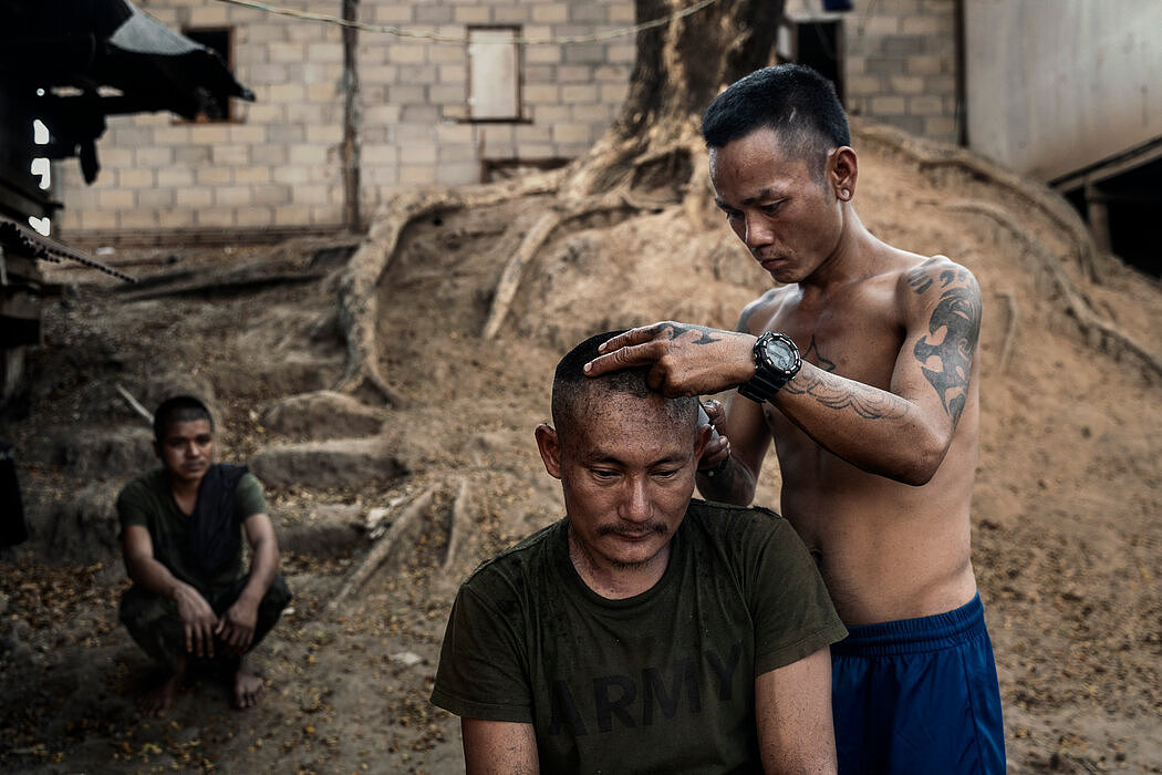 在克伦邦基地，一名克伦族战士在给战友剃头。