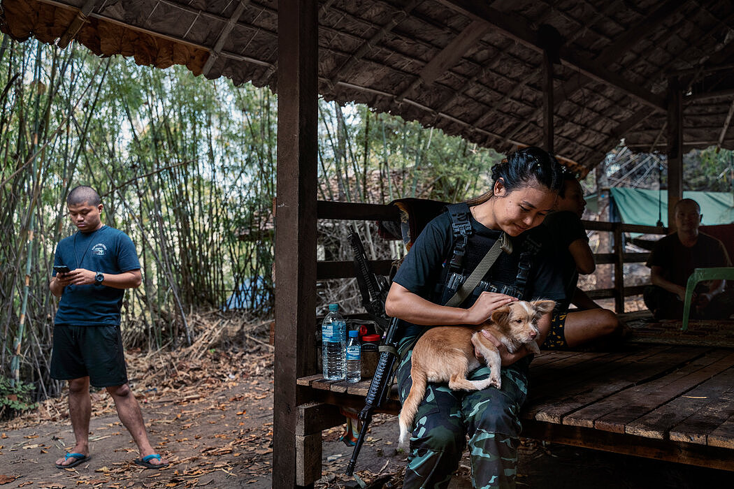 诺缇曾是一名社工，现在是克伦族民兵组织的士官，她在抚摸一只在人民防卫军基地中到处乱跑的小狗。