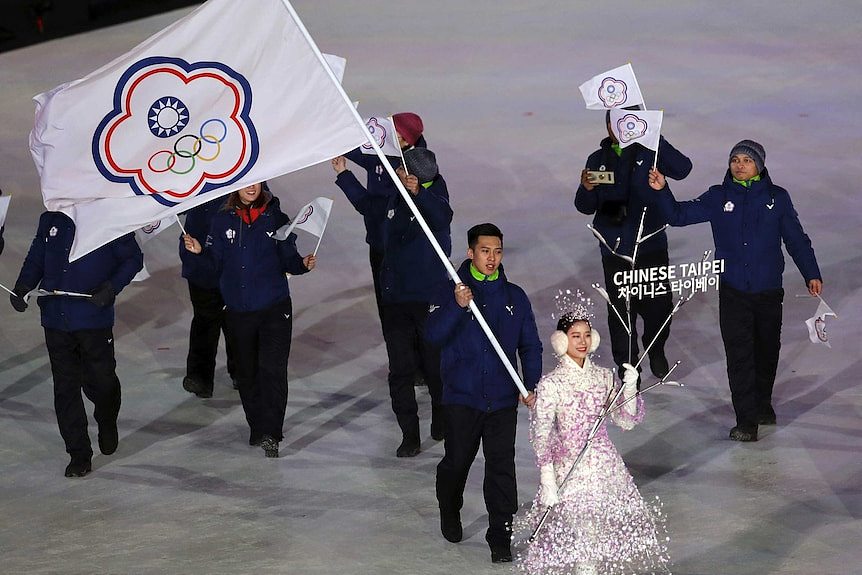 A Taiwanese athlete carries the Chinese Taipei flag representing Taiwan during the opening ceremony of the 2018 Winter Olympics.