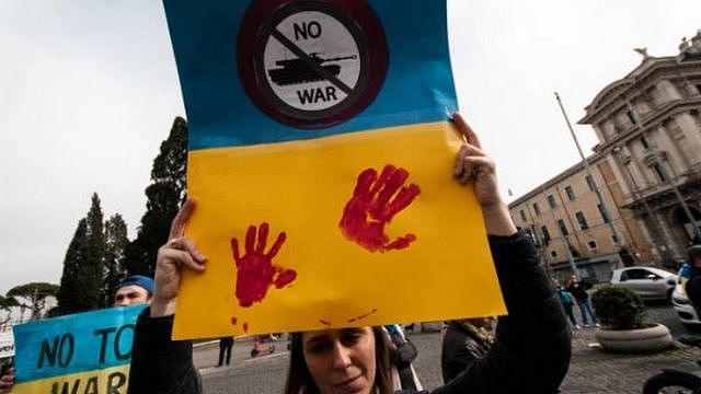 A women hold up a anti-war poster