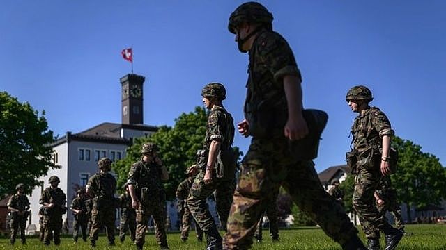 Swiss reservists walk across a field