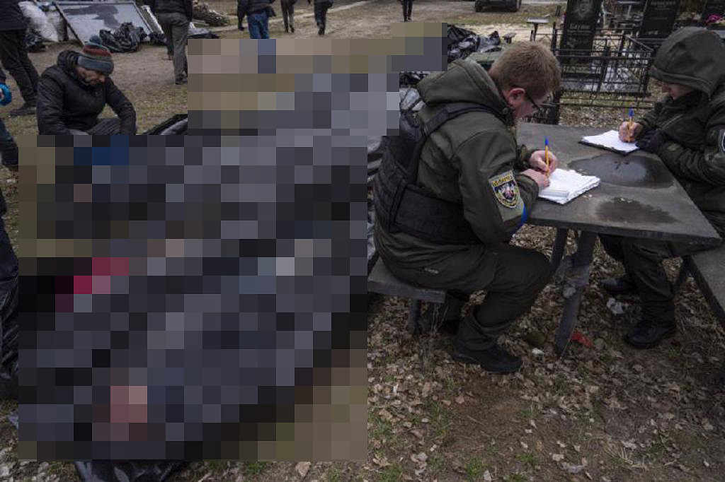 乌克兰收复布查后发现当地犹如人间地狱，至少有400多名布查平民遭俄军屠杀，其中许多是双手被反绑，以行刑方式杀害。 图为乌克兰军警正在清查罹难的布查民众遗体。 （图／美联社）