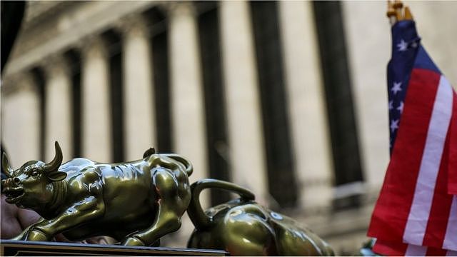 A street vendor sells replicas of the Wall Street Bull statue outside the New York Stock Exchange (NYSE), March 26, 2018 in New York City.