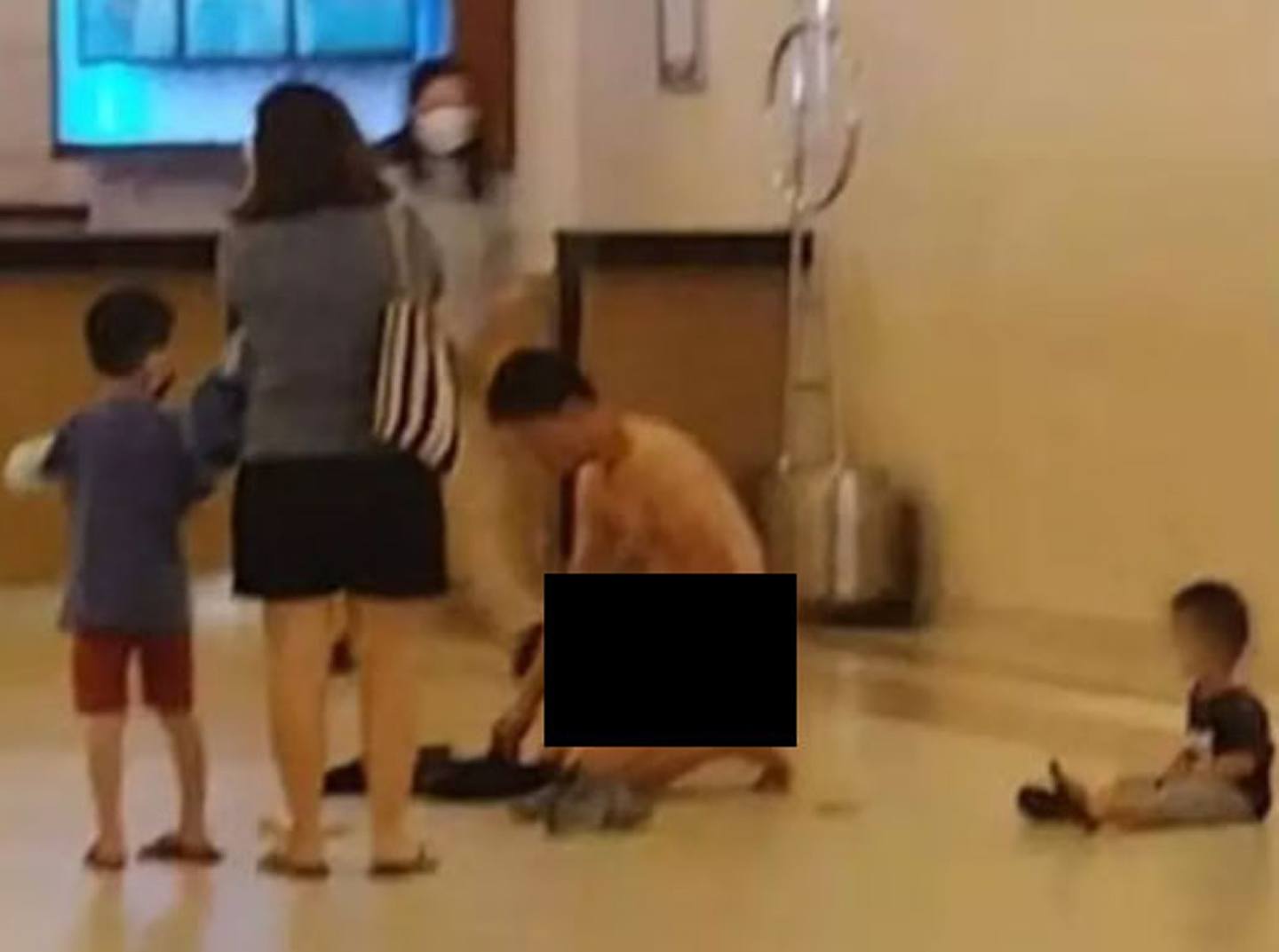 马来西亚一名男子在云顶一间酒店突然脱光衣服下跪，妻儿就在身边，事发地点是酒店大堂，在场人士震惊。 （网传影片截图）