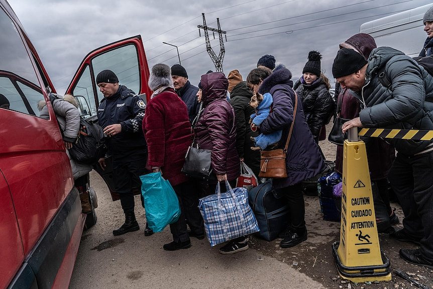 Ukrainian refugees pile into a van on the Moldovan/Ukrainian border.