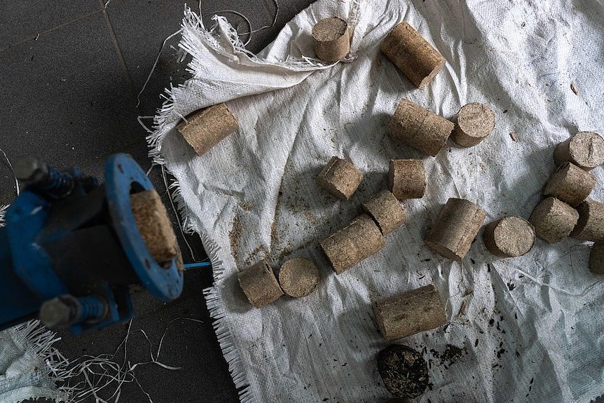 Small pellets of biofuel sit on a white hessian bag.