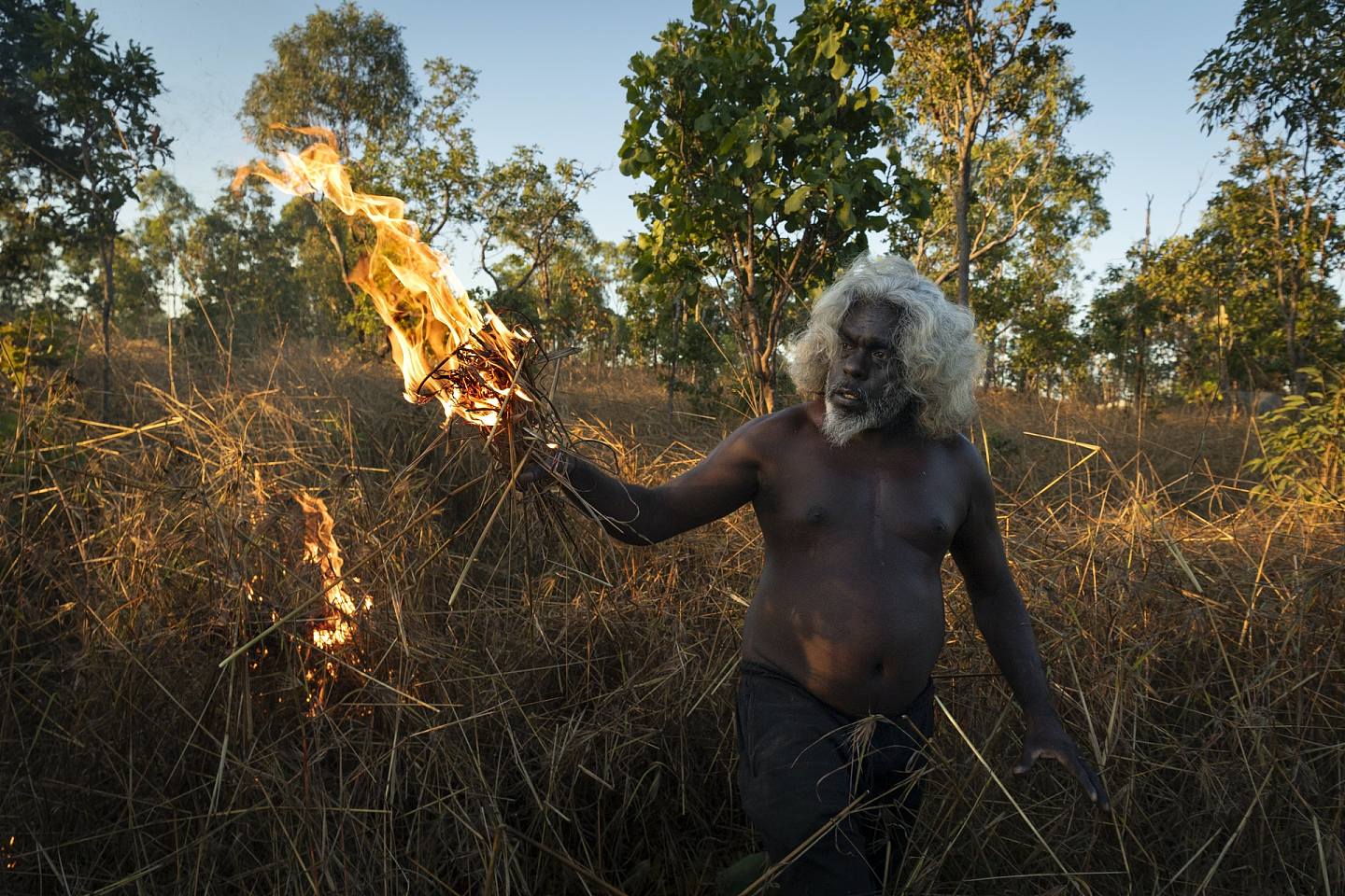 年度图片故事暨东南亚及大洋洲地区最佳图片故事：2021年5月3日，原住民长老Conrad在烧草，以防有过多杂草造成日后山火的助燃物。 （Matthew Abbott 为《国家地理杂志》拍摄／Panos Pictures）