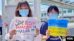 两名大专女生化名阿猫(左）及H同学手持标语参与快闪反战示威，要求俄罗斯停止入侵乌克兰。 (美国之音/汤惠芸)