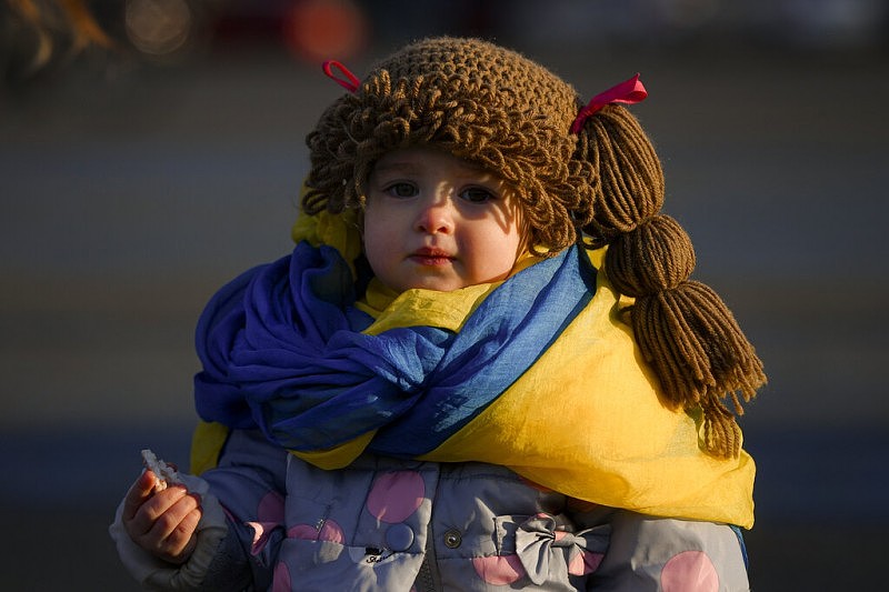 2022年3月19日，僅有一歲大的小Penny圍著烏克蘭國旗顏色的圍巾，在羅馬尼亞跟父母一起參加反戰遊行。（美聯社）