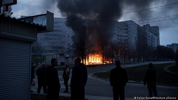 Ukraine, Charkiw | Bewohner stehen nach einem russischen Angriff auf der Straße