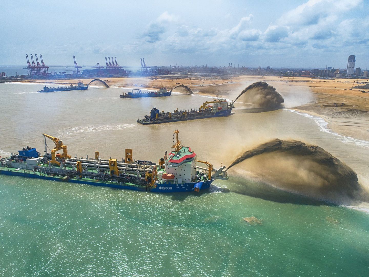 2018年6月20日在斯里兰卡科伦坡港口城拍摄的“浚洋1”、“万顷沙”等四艘耙吸船同时虹喷场景。（新华社）