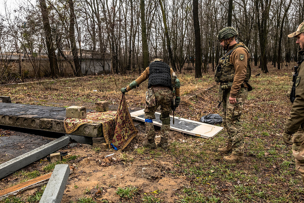 乌克兰亚速营的士兵检查了一个地下空间，那里有一男一女两名平民的尸体被丢弃。