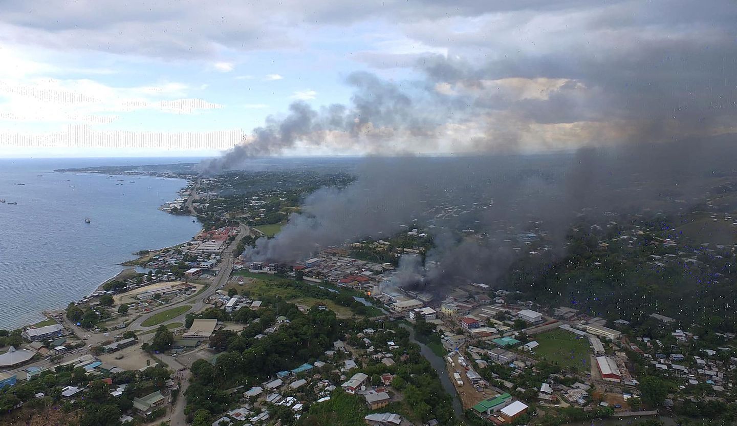 2021年11月25日，在所罗门群岛首都霍尼亚拉，燃烧的建筑物冒出浓烟。（Getty）
