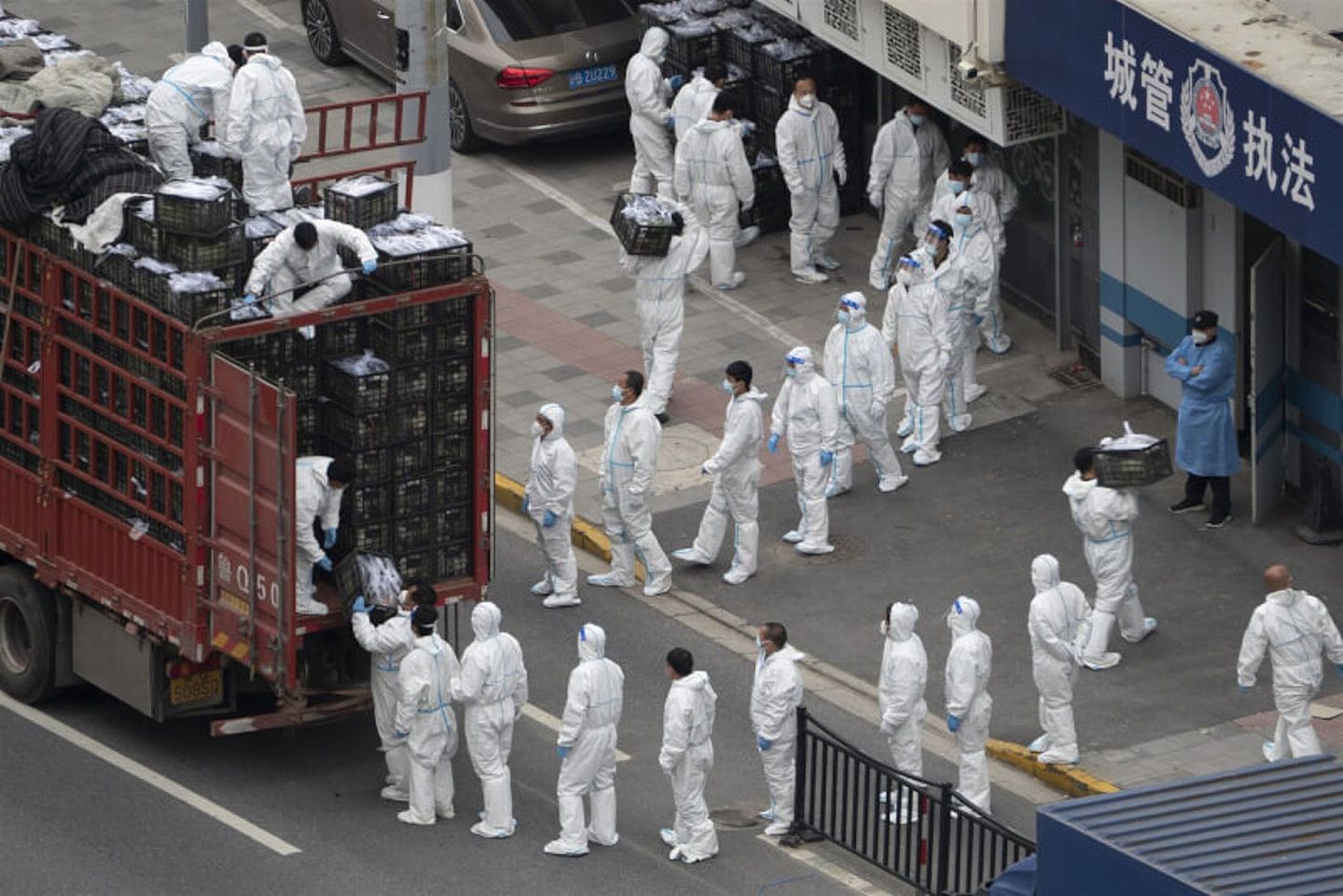 上海疫情持续，图为5日上海杨浦区穿著防护衣的防疫人员协助运送物资。（中新社）