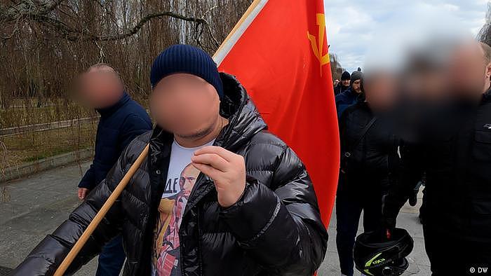 柏林的示威者：普京在T恤上，锤子和镰刀在国旗上