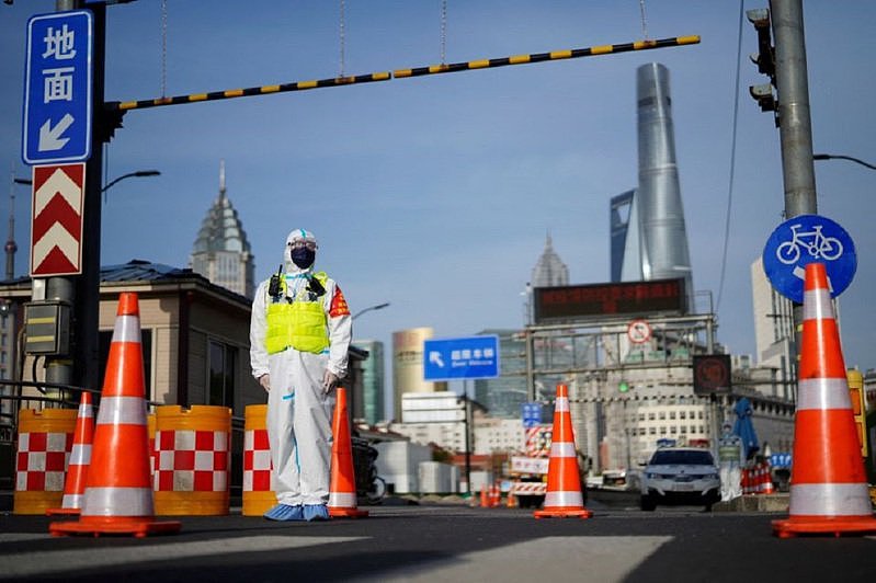 图为上海遏制新冠病毒传播，一名身穿防护服的警察在黄浦江对岸通往浦东地区的隧道入口处守候。 路透