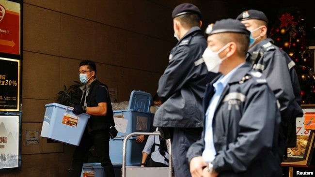 资料照：2021年12月29日，香港一名警察在搜查了《立场新闻》办公室后收集了一箱证据。（路透社）