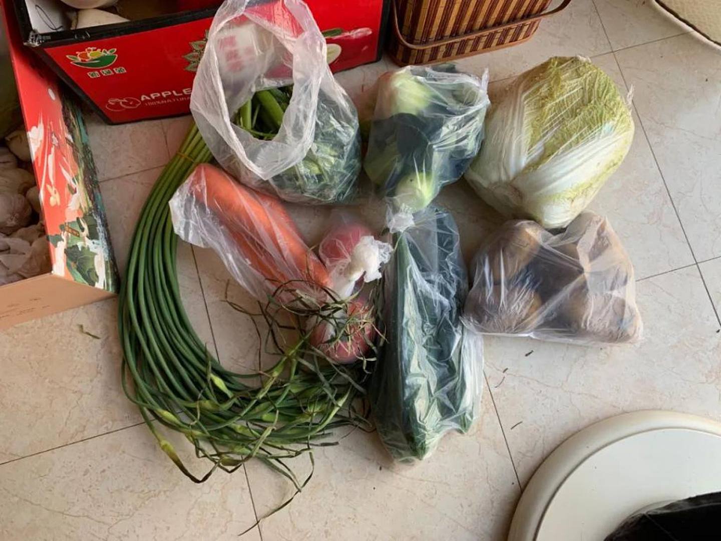 武漢疫情期間通過社區購買的 70 元蔬菜套餐，包含一把蒜薹、三根胡蘿蔔、兩顆上海青、一袋豌豆、兩個西紅柿、四根黃瓜和一個大白菜。（ZAKER）