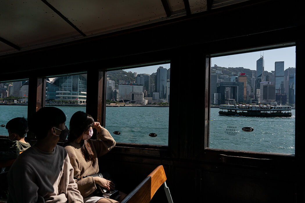 乘客乘坐天星小轮，欣赏香港的壮丽景色。