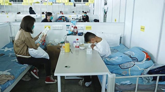 A child accompanied by their mother studies while receiving treatment in the quarantine zone at the Shanghai New International Expo Center on April 10, 2022 in Shanghai,