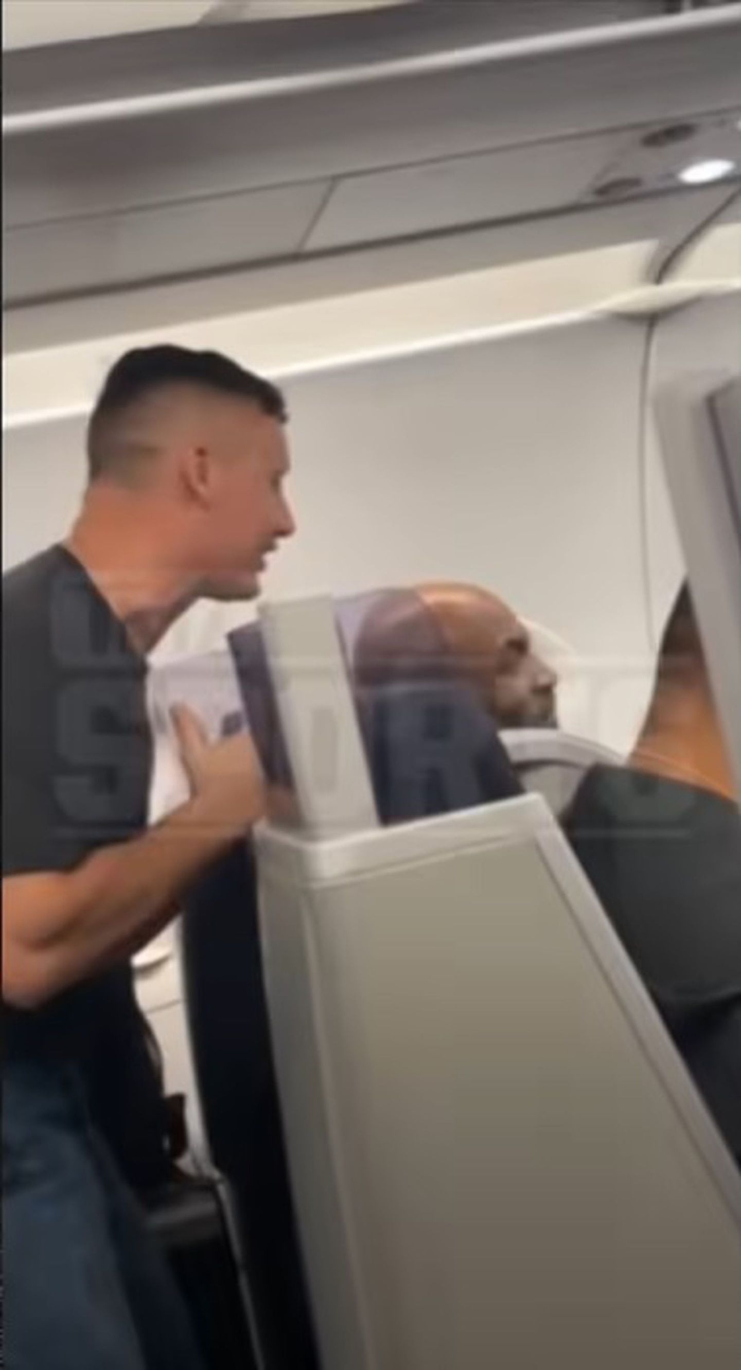 图为4月21日飞机上，左方男子一直在骚扰坐在前方的泰臣。（TMZSports Youtube截图）