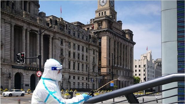 A sanitation worker wearing personal protective equipment (PPE) sprays disinfectant at the Bund on April 18, 2022 in Shanghai