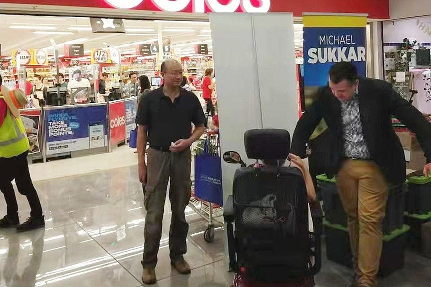 michael sukkar and a man speaking to constiuents in a shopping centre