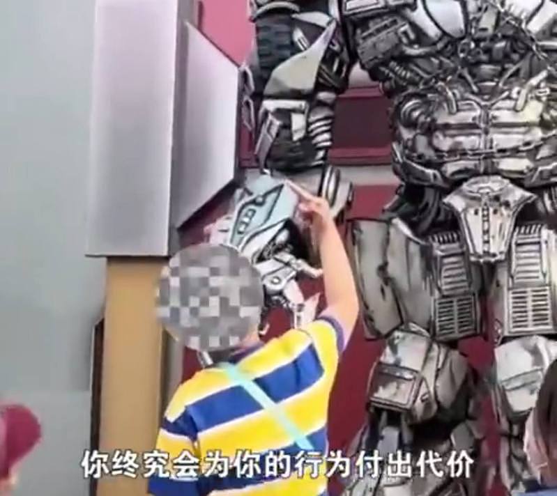 北京环球影城内，一名男孩对「威震天」比中指踢。（影片截屏）
