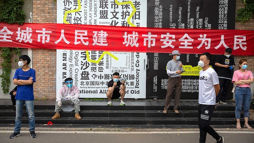 People wait outside a COVID-19 testing site after being ordered to be tested, following the Beijing outbreak.