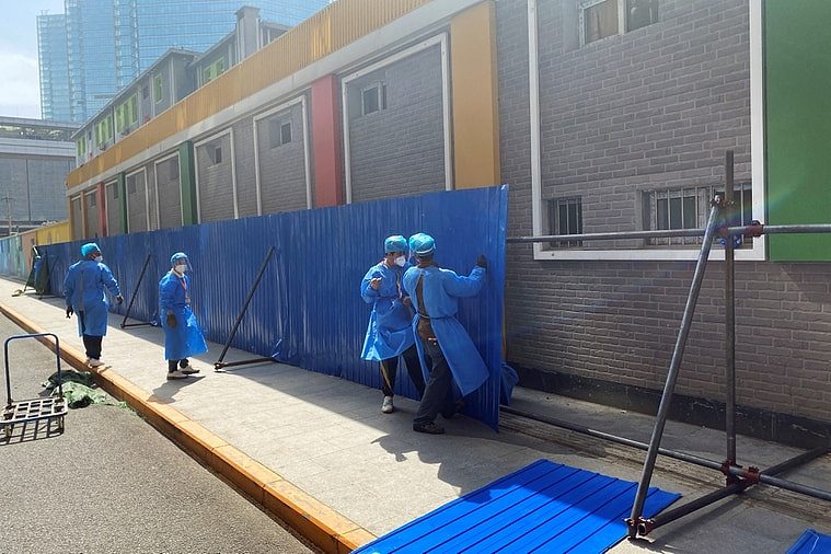 工作人员4日在北京划定管控区、封控区的朝阳区民宅外，搭设围栏，防止民众违反防疫规定外出。 路透