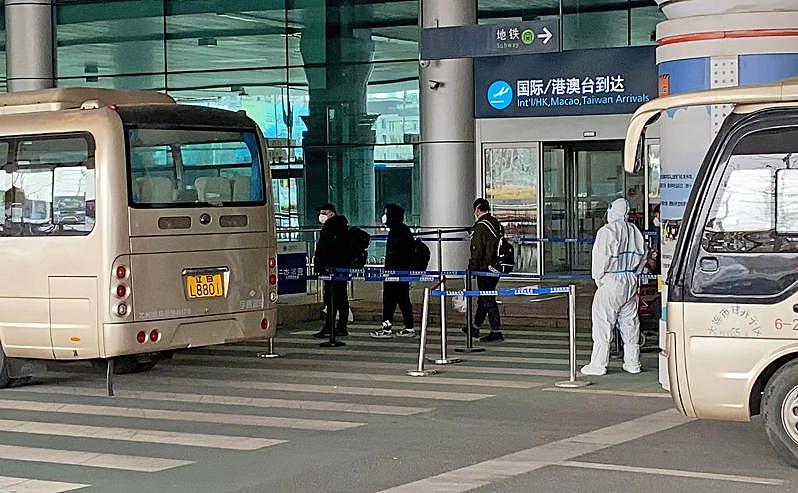 境外航班抵达中国后，旅客要搭乘大巴前往隔离酒店。(新华社)