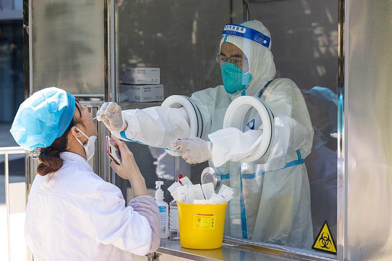 上海全市市民每天都必须进行一次核酸PCR或快筛检测。 图为黄浦区一处「15分钟核酸服务圈」易检小站，医务人员为附近居民做核酸采样。 （新华社）